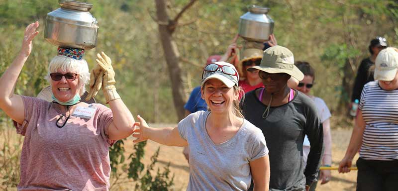 women carrying water in india volunteers