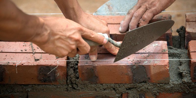 Volunteers building in Myanmar with bricks