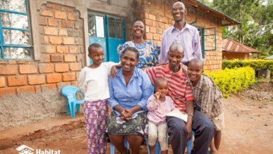 a beneficiary family sat in front of their new home