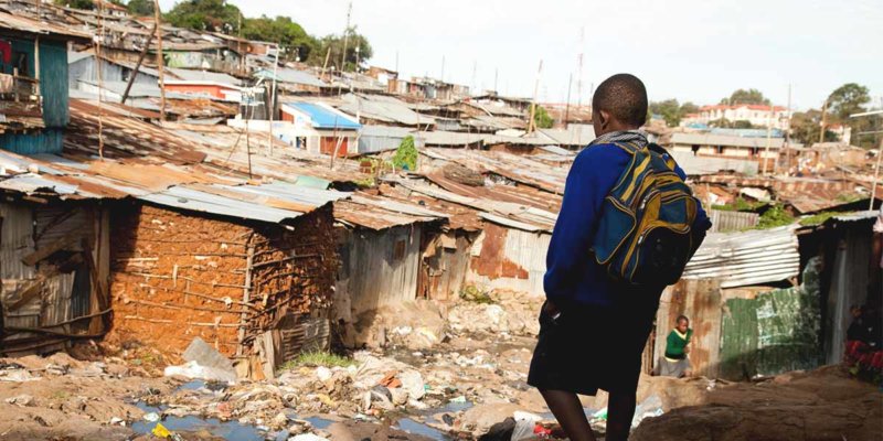 boy walking through slums