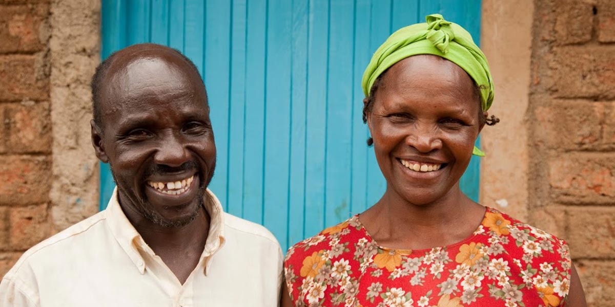 a couple smiling outside their own home