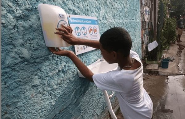 Wash - water sanitation and hygiene poster being put up by a child
