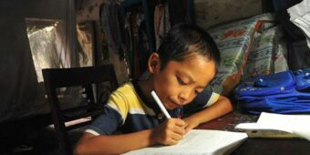 a BOY WRITES HIS HOMEWORK IN HIS NEW HOUSE