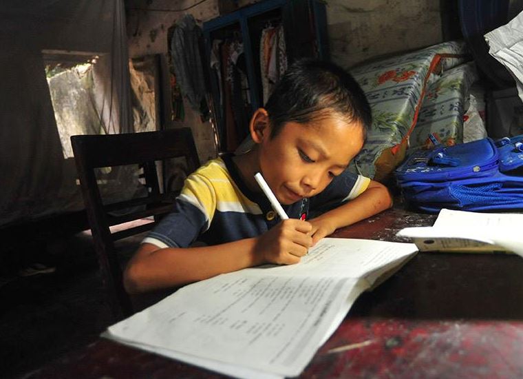 a BOY WRITES HIS HOMEWORK IN HIS NEW HOUSE