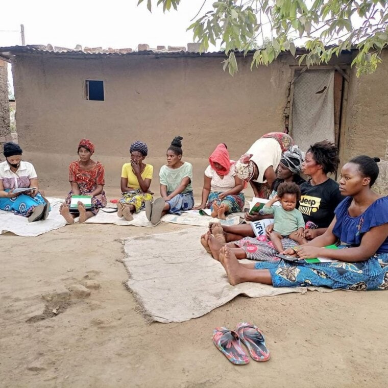 savings group in Zambia. women gathered in a study circle group to learn about finances and land rights