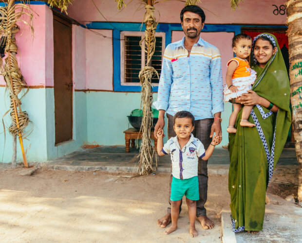 India - a family stand in front of their new home