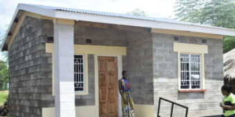 person in Malawi gather around a new Habitat for Humanity home