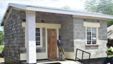 person in Malawi gather around a new Habitat for Humanity home