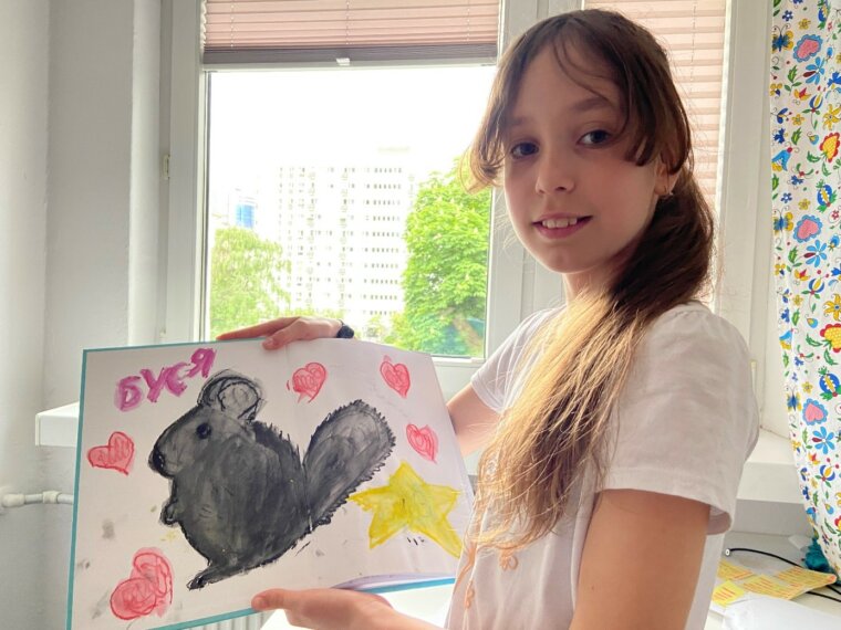 Krisitna showing a drawing of Busia - her beloved chinchila Poland - Ukraine