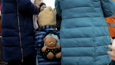 refugee child with teddy on his back from Ukraine