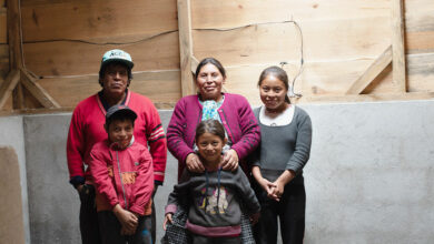 Maria and her children stand in a room within their new hybrid home in Guatemala