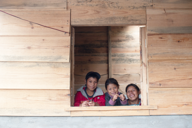 Maria and two of her children look through one of their new windows - Guatemala