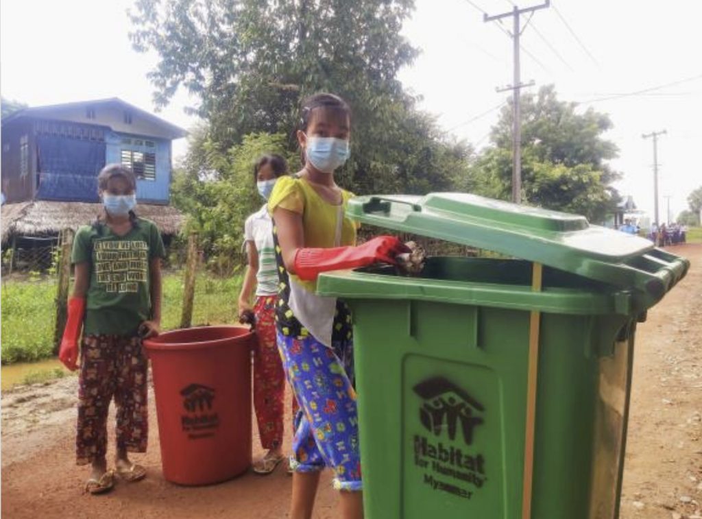 In Myanmar a woman helps with the clear-up of rubbish on the streets