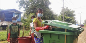 In Myanmar a woman helps with the clear-up of rubbish on the streets