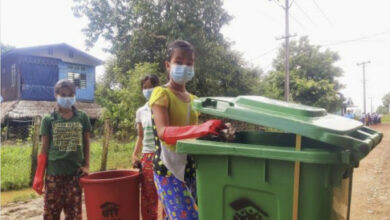 In Myanmar a woman helps with the clear-up of rubbish on the streets