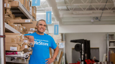 A ReStore staff member stood smiling with a hand on their hip