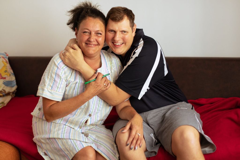 Tetiana and her son Denys, embracing one another and smiling after fleeing Ukraine and finding hope in Bucharest