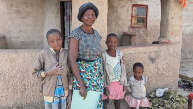 Tasila outside her house in Makalulu, Zambia with her family
