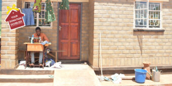 Imraan Chisanga an 18 year old tailor trained by Habitat for Humanity Malawi after Cyclone Freddy, sat outside of his new Habitat for Humanity home, using a sewing machine to tailor clothing