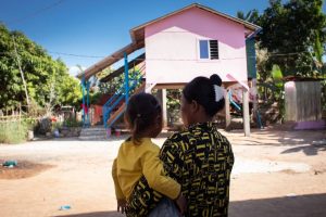 A mother and child admire their new Habitat home in Cambodia