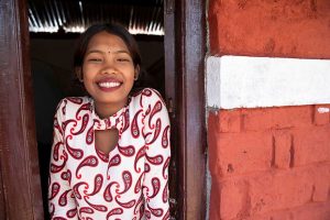 A Habitat homeowner in Nepal smiling from the window of their home