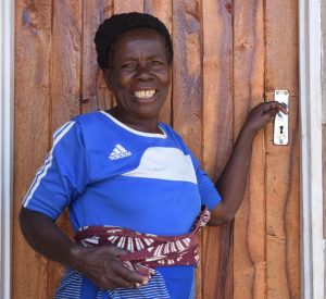 A Habitat homeowner in Malawi about to open the front door of their new home