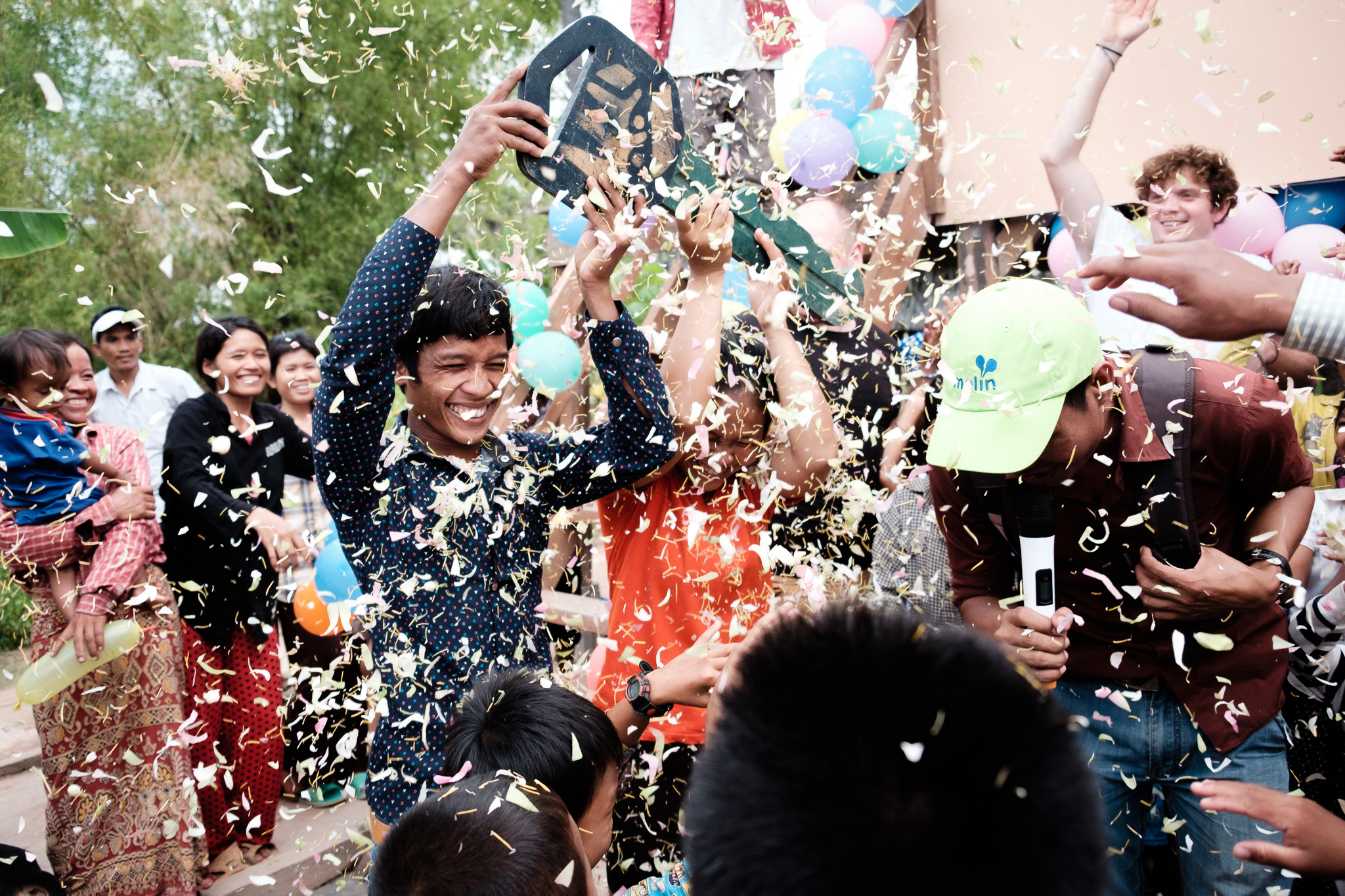 Families in a Cambodian community celebrating with confetti at a Habitat for Humanity build