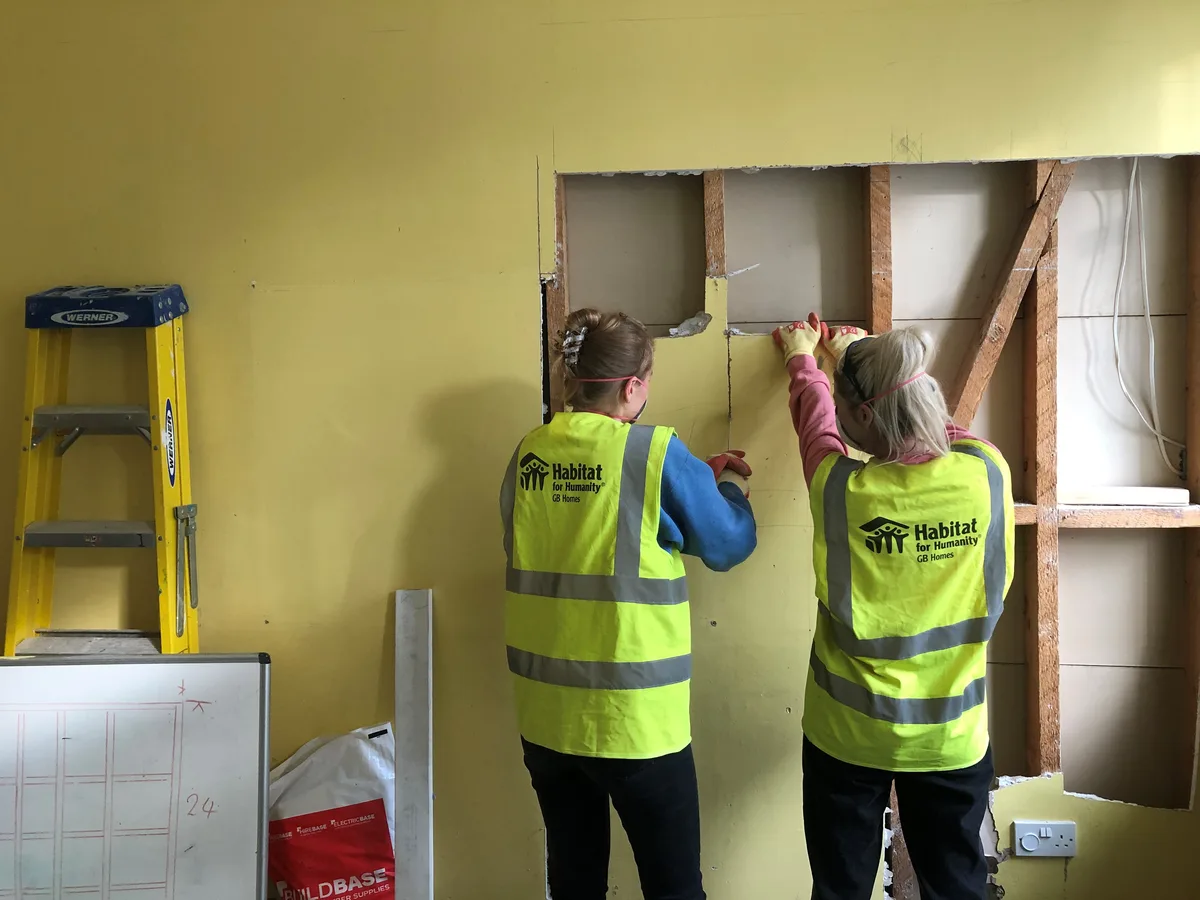 Volunteers in hi-vis vests decorating a room