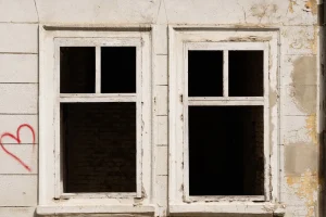 Empty windows in a derelict, boarded-up building awaiting conversion into homes