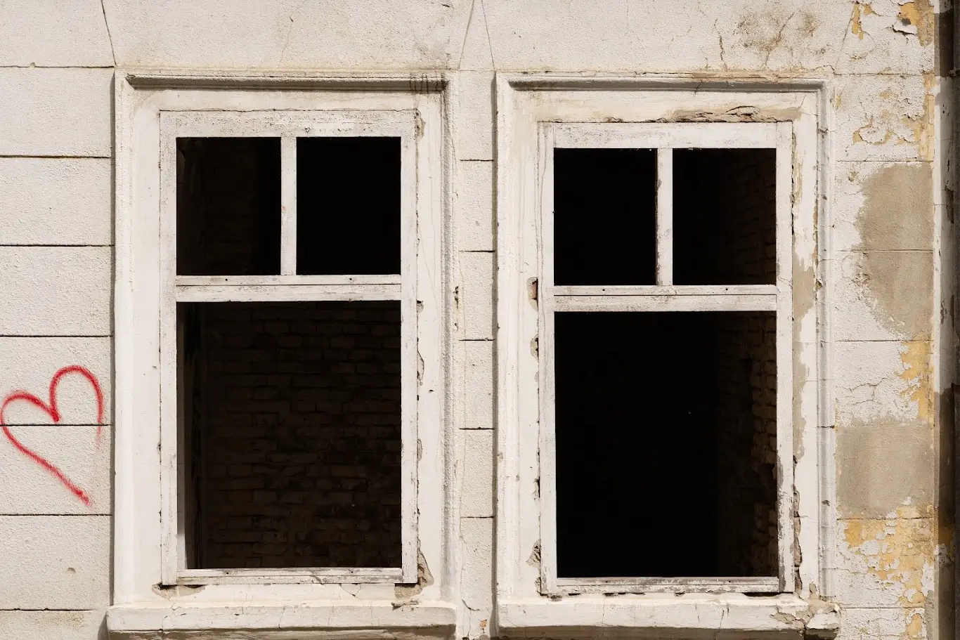 Empty windows in a derelict, boarded-up building awaiting conversion into homes