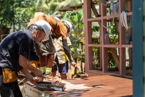Three men building the timber frame of a house in Fiji with Habitat for Humanity