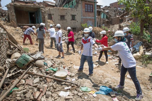 Volunteers clearing rubble from destroyed houses after a disaster