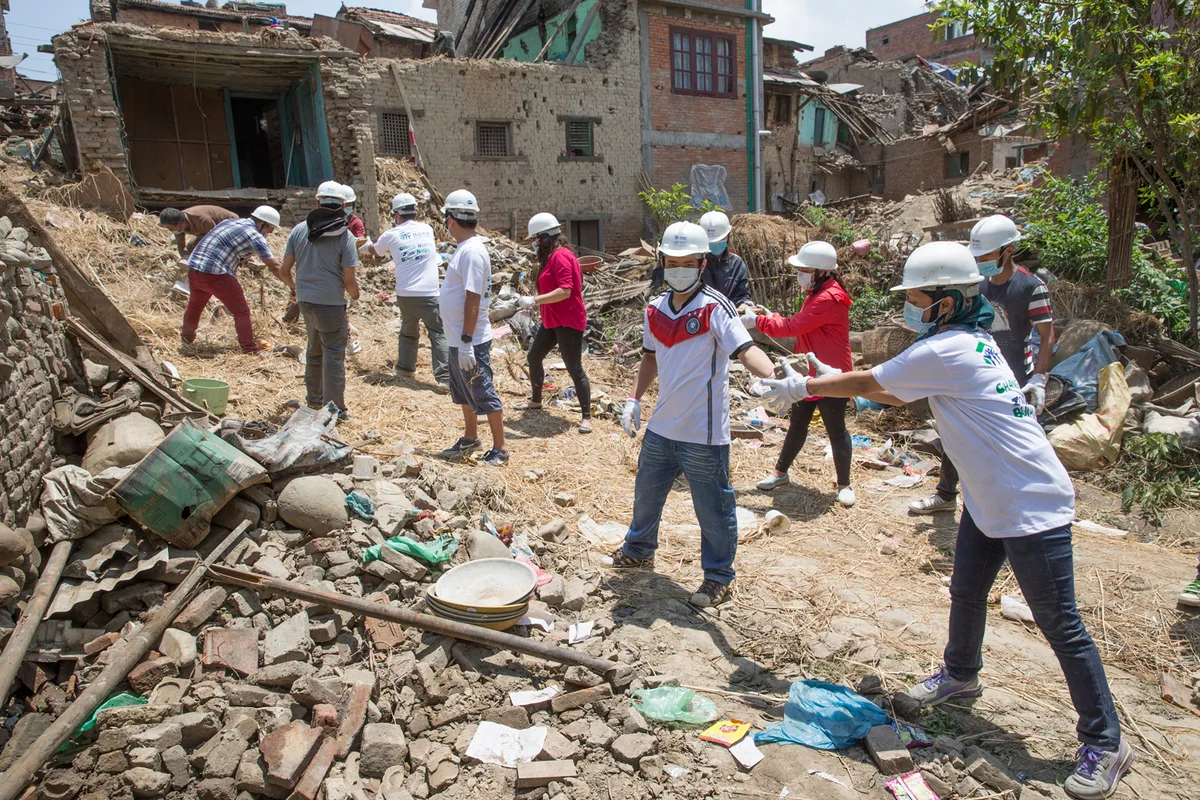 Volunteers clearing rubble from destroyed houses after a disaster