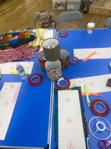 Craft materials - coloured tape, paper and scissors - on a workshop table