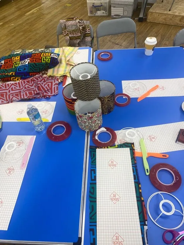 Craft materials - coloured tape, paper and scissors - on a workshop table