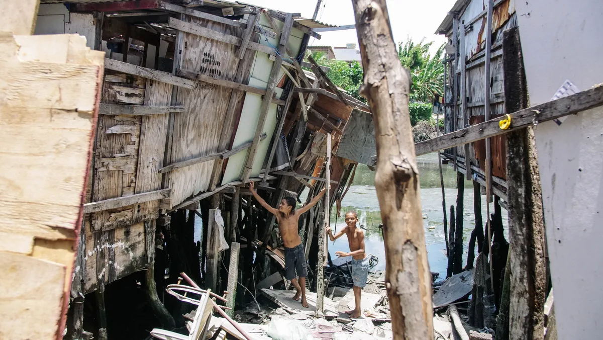 Two children playing in the remnants of a destroyed house