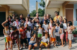 A large group of volunteers, children and families together at a Habitat project